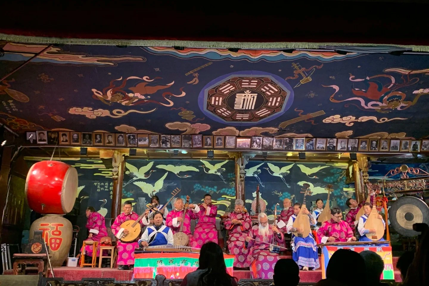 Naxi Ancient Music Hall concert with elder musicians on stage playing traditional flutes, strings, and percussion
