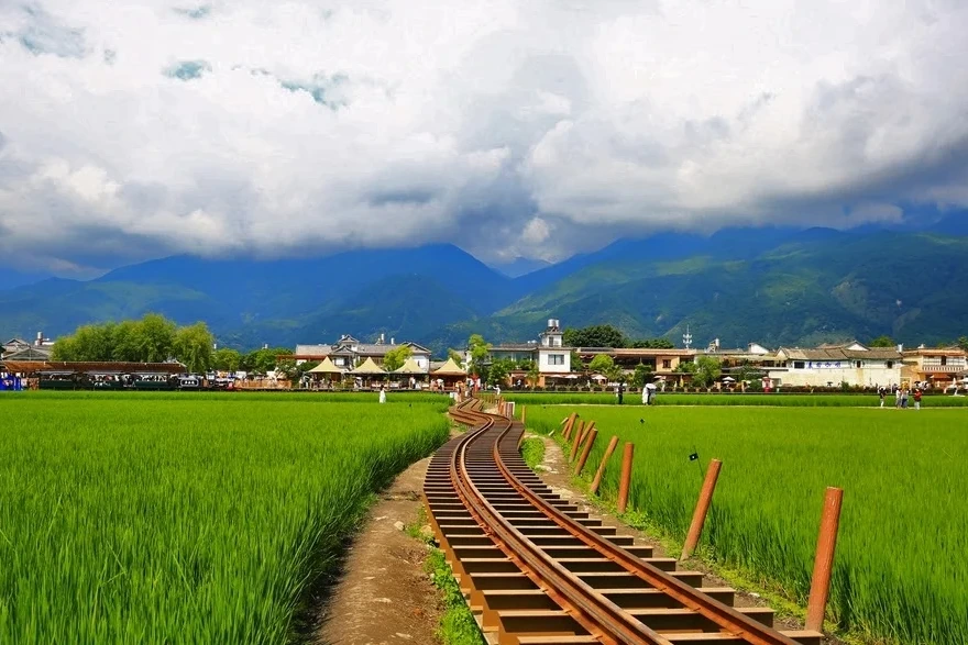 Xizhou wheat fields with old railway track and Bai village houses