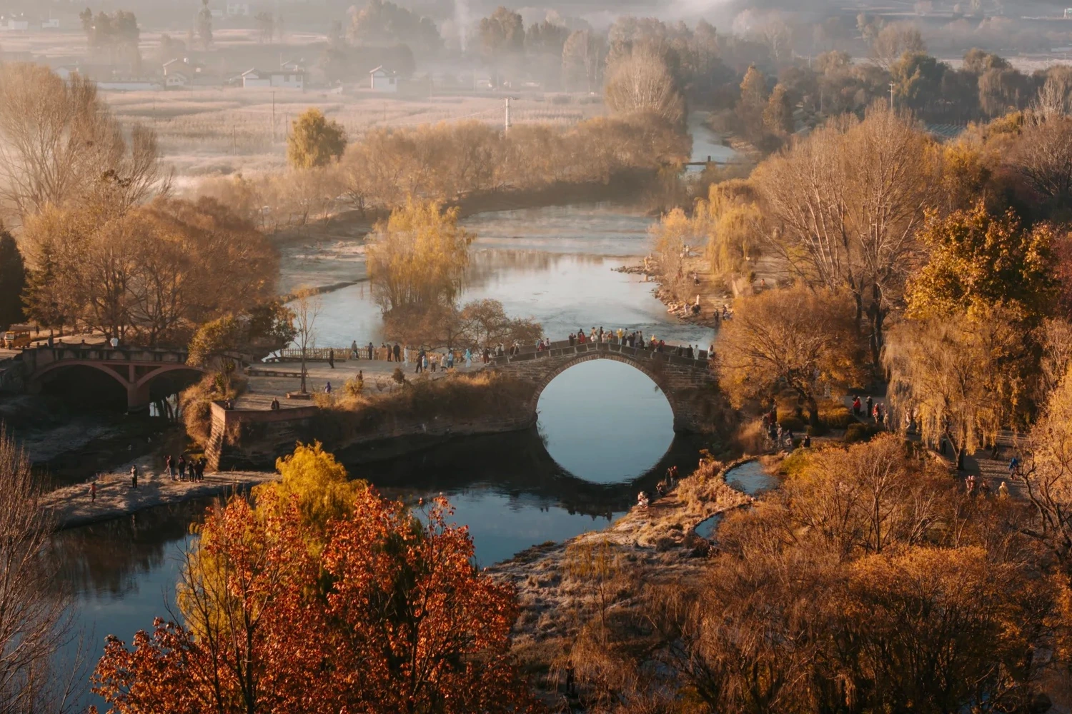 Yujin Bridge over Heihui River at Shaxi Ancient Town with red leaves