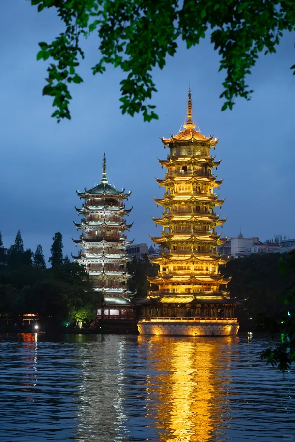 Sun and Moon Twin Pagodas illuminated at night by the lake